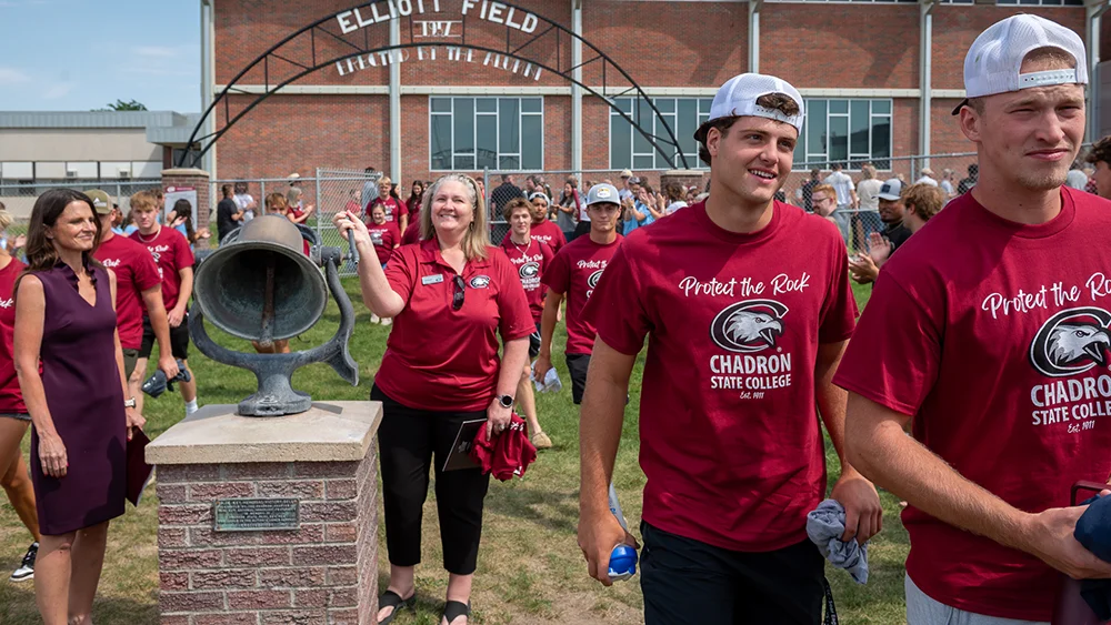 CSC President Jodi Kupper rings the bell at Elliott Field as new students enter the field