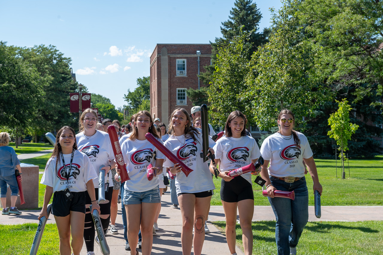 group of students walking down main sidewalk of campus during move in