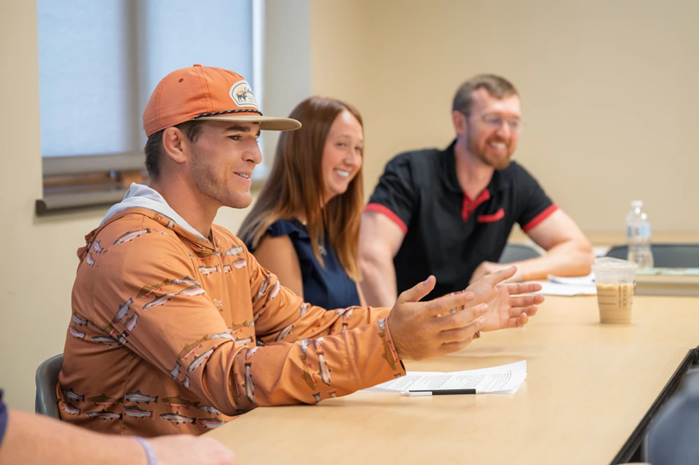 Two students and a professor in a group discussion