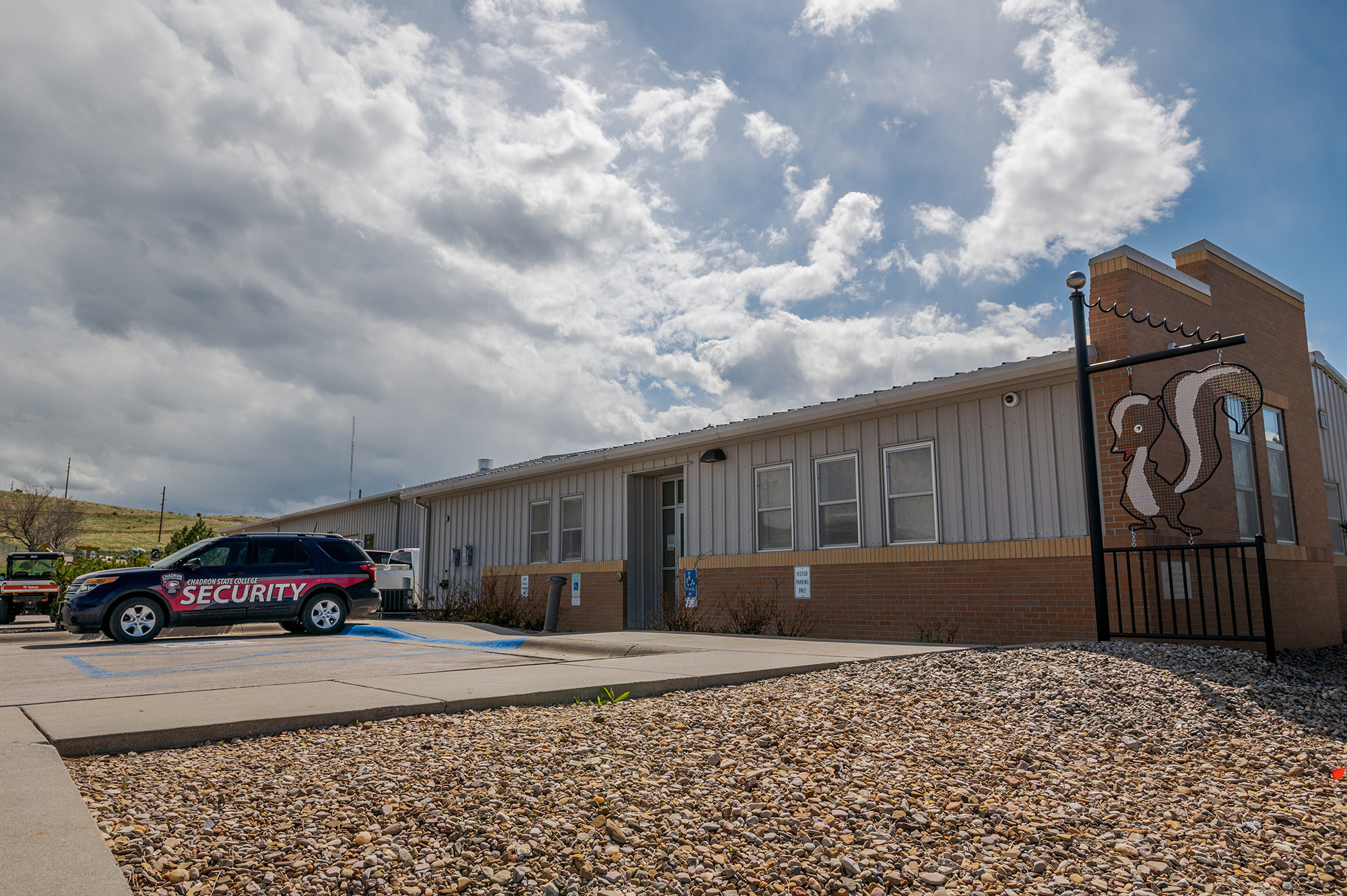 Photo of the maintence building with a security vehicle parked in front