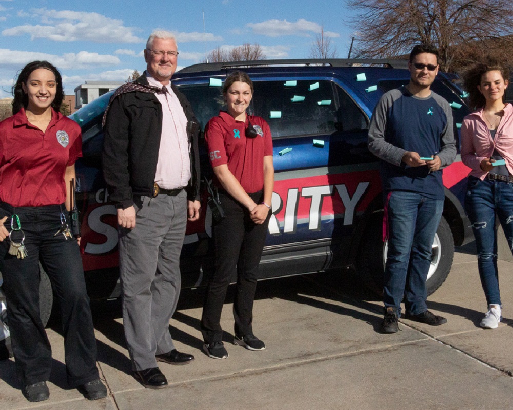 Photo of the campus security team next to one of their vehicles