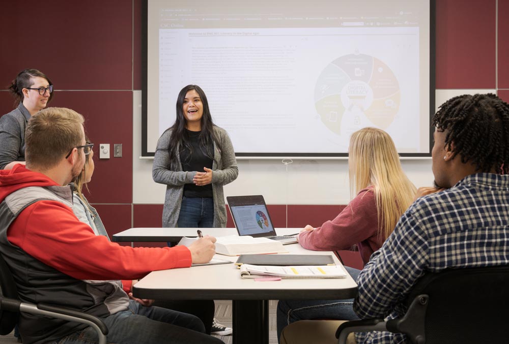 Student speaking from front of classroom to other students