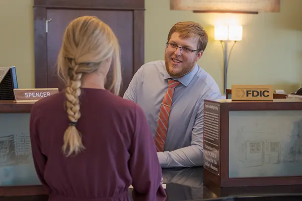 A woman speaks to a bank clerk